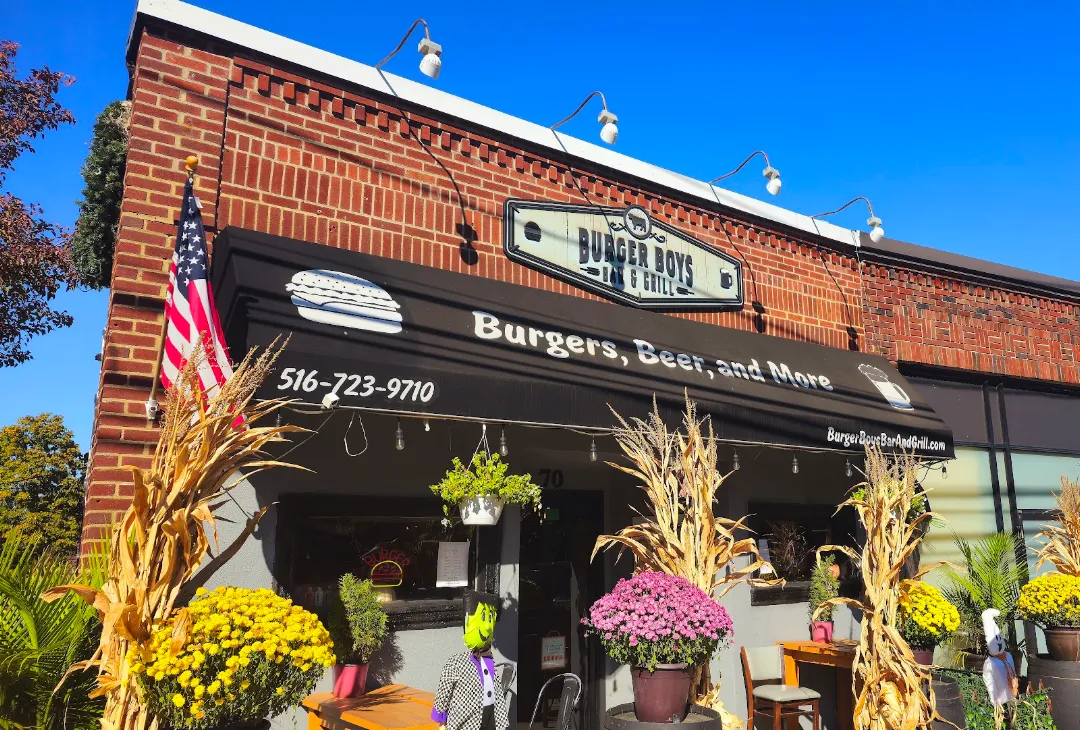 Burger Boys Bar & Grill storefront in Glen Cove with fall mums and cornstalks