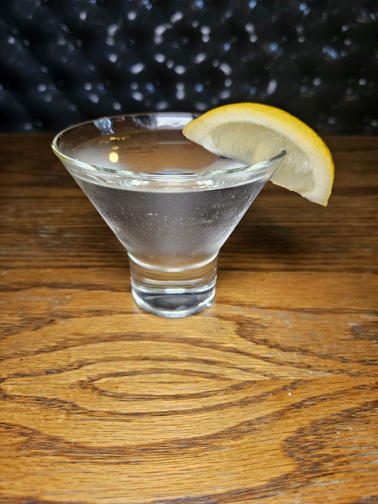 Chilled martini with a lemon wedge on the bar top